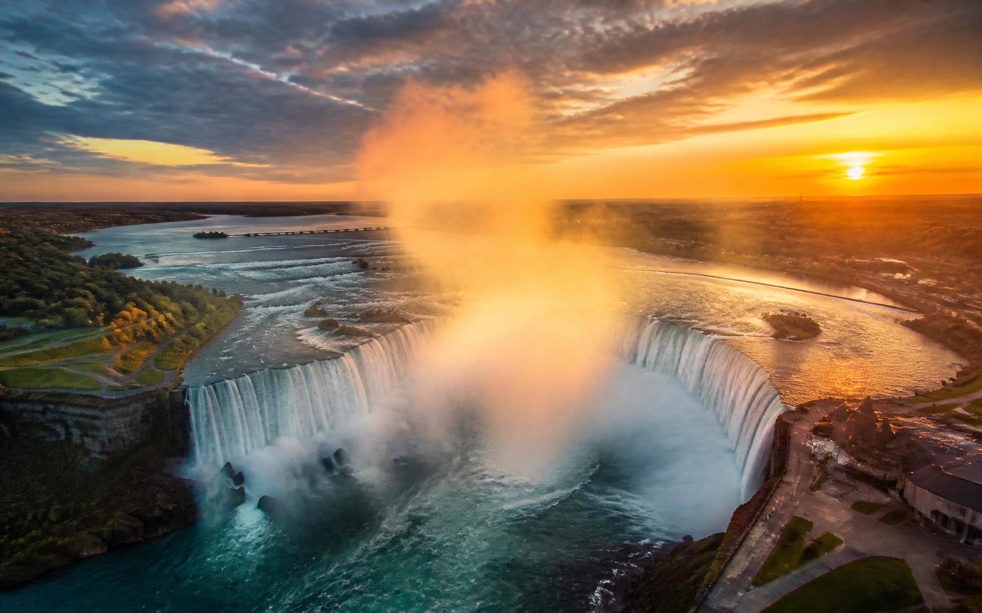 Aerial view of Horseshoe Falls at sunset with mist rising over the Niagara River
